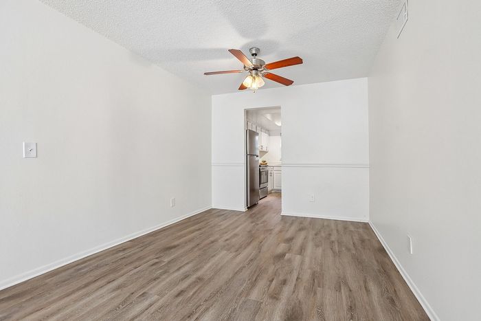 Bright and airy dining area with elegant hardwood flooring adjacent to a sleek, contemporary kitchen.