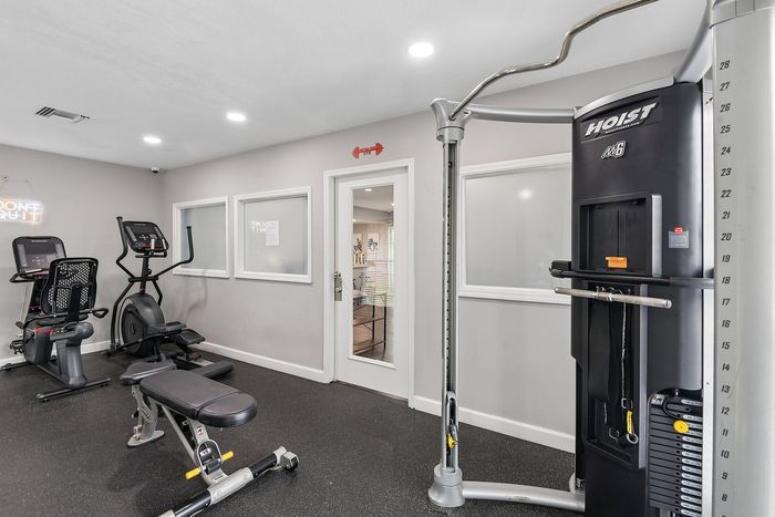 Modern apartment fitness center equipped with state-of-the-art exercise machines and bright, inviting interiors.