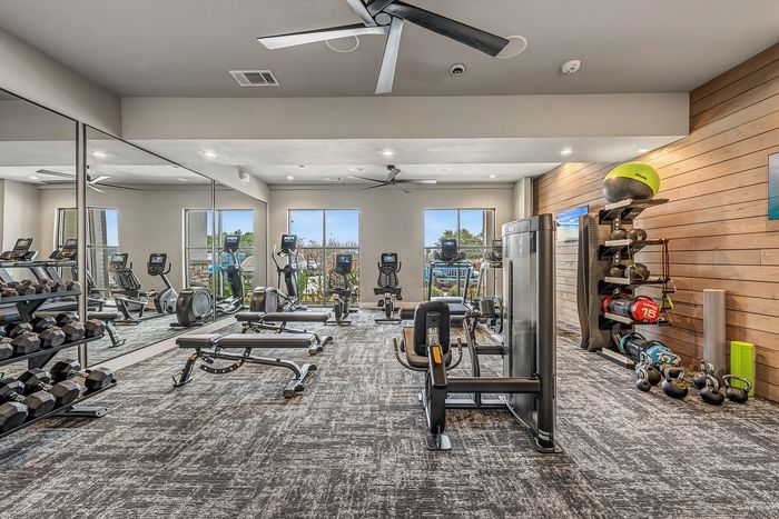 Modern fitness center with state-of-the-art equipment, bright natural lighting, and sleek design.