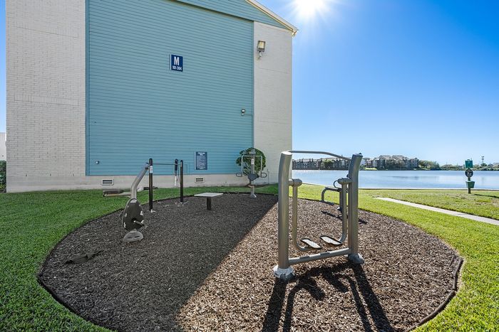 Lakeside at Campeche Outdoor Fitness Area in the shade of aa building is aa prime spot to hit your fitness goals while enjoying the fresh air and the amazing lake side views