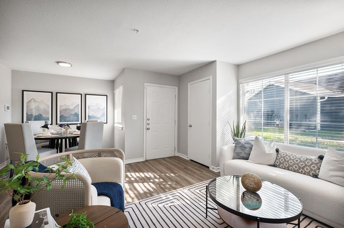 Bright and inviting living room with modern decor, plush seating, and expansive window views.