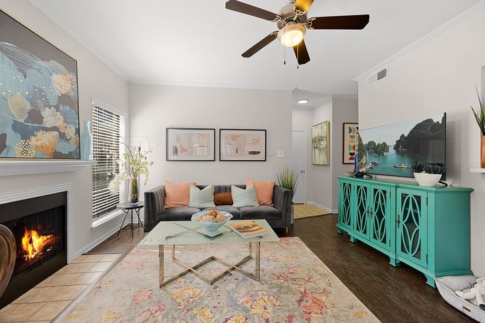 Charming living room with a cozy fireplace, stylish decor, and a vibrant teal cabinet, perfect for a warm and inviting ambiance.