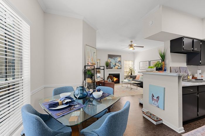 Elegant open-concept living space with chic dining area, cozy fireplace, and modern kitchen, perfect for entertaining.