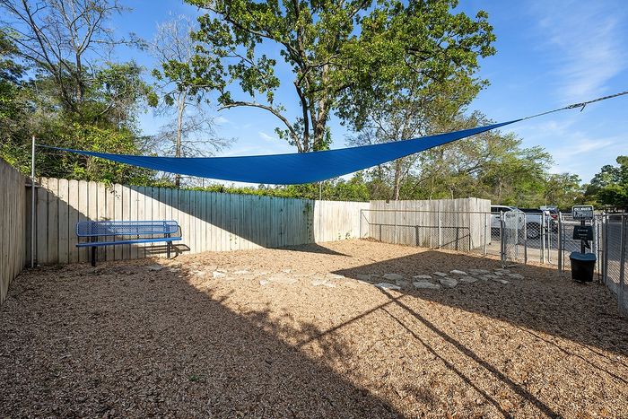Charming outdoor space featuring a cozy bench, shaded area, and fenced surroundings perfect for relaxation.