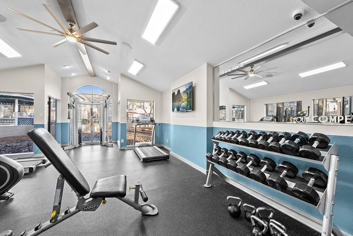 Modern fitness center with state-of-the-art equipment, featuring a range of free weights, treadmill, and weight benches in a bright, inviting space.