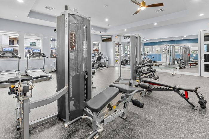 Modern fitness center with state-of-the-art gym equipment including treadmills, weight benches, and resistance machines, designed for a premium workout experience.