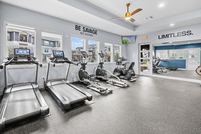 Modern apartment gym with state-of-the-art treadmill and cycling equipment, bright natural light, motivational quotes, and sleek design.