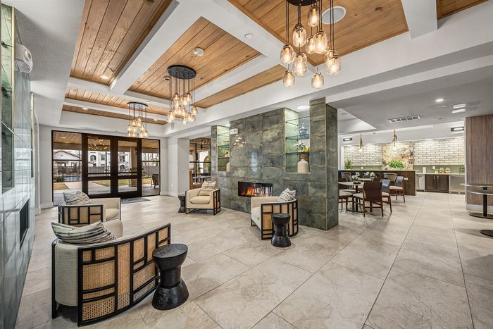 Chic recreational room with modern pool table, stylish brick walls, comfortable seating, and elegant lighting.