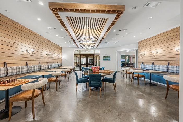 Chic recreational room with modern pool table, stylish brick walls, comfortable seating, and elegant lighting.