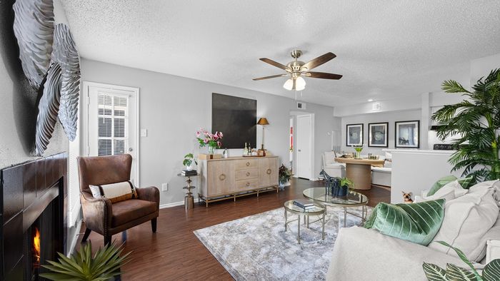 Inviting living room with elegant decor, featuring a cozy fireplace, stylish seating, and lush green plants for a relaxing atmosphere.