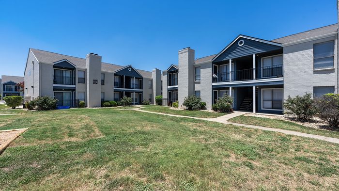 Charming apartment complex with modern architecture, lush green landscaping, and a vibrant community atmosphere.
