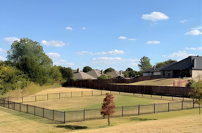 Scenic suburban landscape with charming houses and a fenced grassy area, perfect for outdoor enjoyment under a vibrant blue sky.