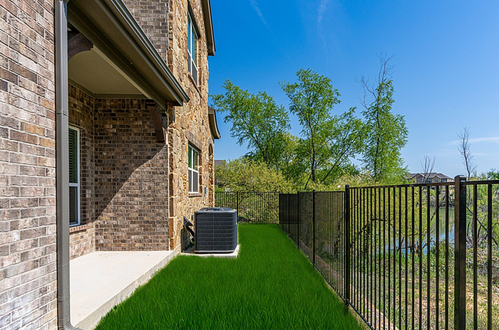 Charming brick home with lush green backyard and scenic nature view, perfect for relaxation and outdoor enjoyment.