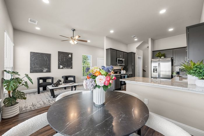 Bright and modern open-concept living area with elegant kitchen, chic decor, and vibrant floral centerpiece.