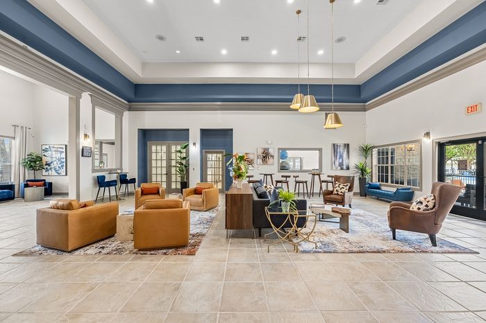 Elegant lounge area featuring modern decor, plush seating, and stylish lighting fixtures, perfect for relaxing or entertaining in a sophisticated apartment community.