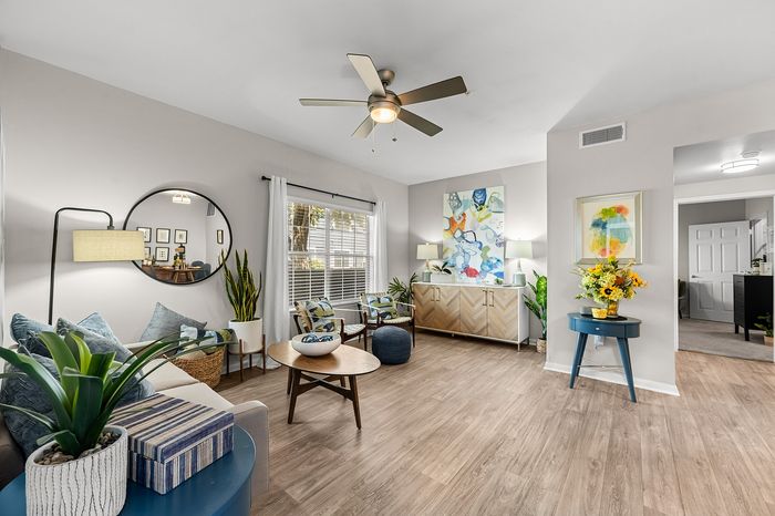 Bright and inviting living room with modern decor, featuring large windows, stylish furniture, and vibrant artwork, creating a welcoming and elegant atmosphere.