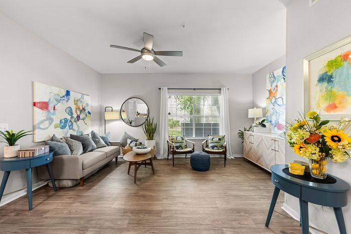 Bright and airy living room featuring modern decor, vibrant art pieces, and upscale furnishings for a cozy ambiance.