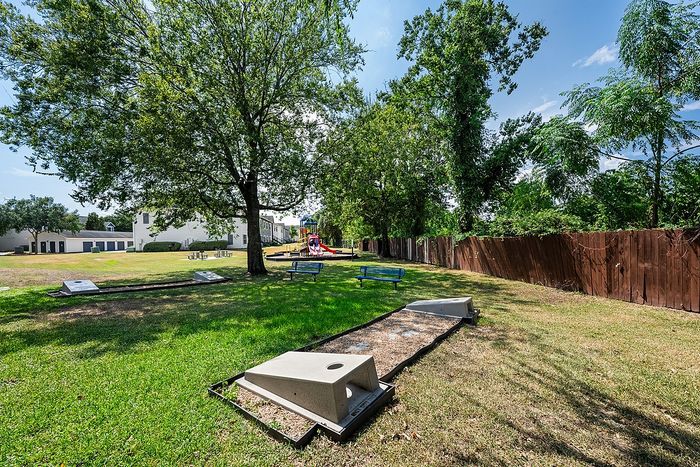 Inviting community park with vibrant playground, picnic benches, and lush greenery, perfect for family gatherings.