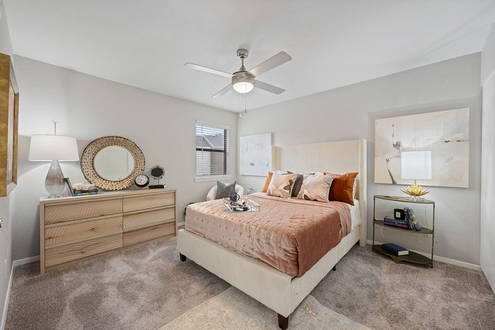 Inviting bedroom with elegant decor, featuring a plush bed, chic side tables, and stylish artwork, all illuminated by soft natural light.