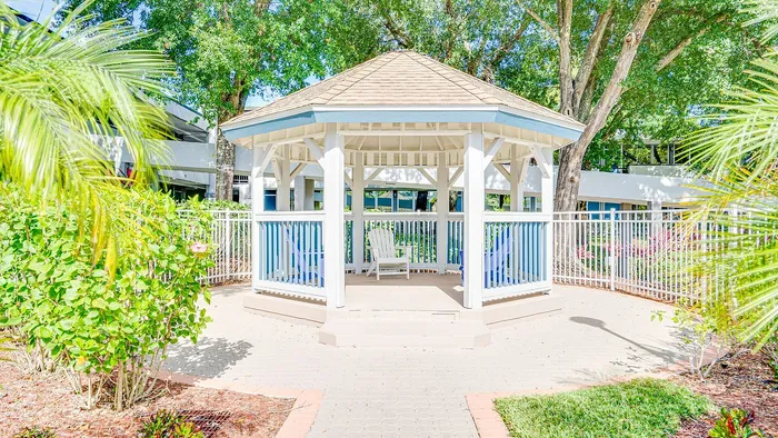 Charming gazebo nestled in lush, landscaped greenery, offering a serene outdoor retreat.