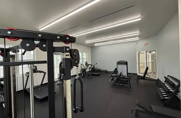 Gym interior showing various strength training machines and weight equipment.