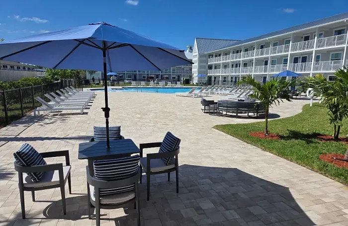 Charming apartment residences featuring modern architecture surrounded by palm trees.