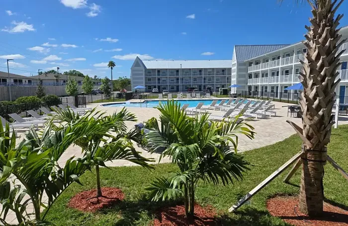 Inviting outdoor pool area surrounded by lush greenery and a stylish fence, perfect for relaxation and leisure.