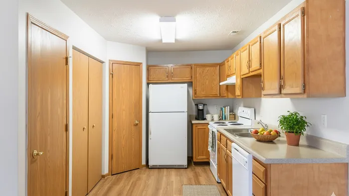 Inviting kitchen with warm wooden cabinetry, sleek countertops, modern appliances, and cozy lighting.
