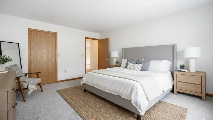 Bright and inviting bedroom featuring a cozy queen-sized bed, elegant nightstands, and tasteful decor accents.