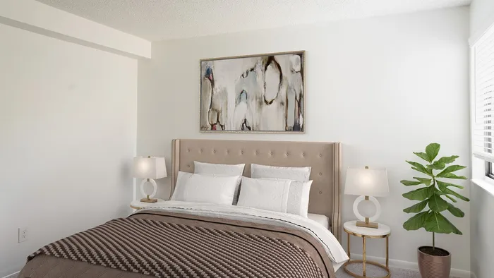 Elegant bedroom featuring a plush bed with a tufted headboard, chic bedside lamps, and a vibrant potted plant for a touch of nature.