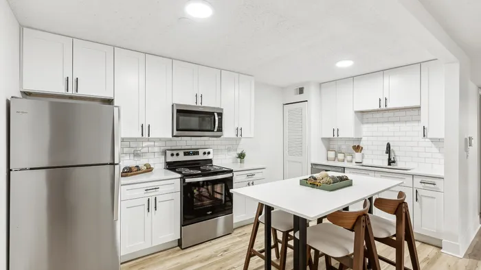 Modern kitchen with sleek white cabinetry, stainless steel appliances, and elegant subway tile backsplash.
