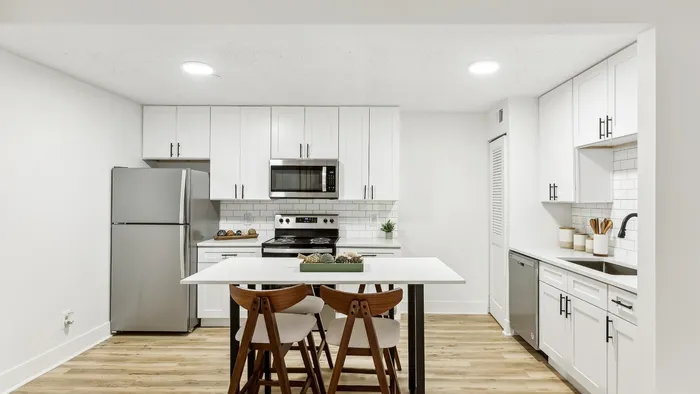 Modern kitchen with sleek stainless-steel appliances, white cabinetry, and a chic breakfast island.