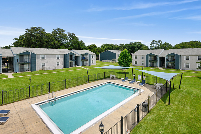 Charming apartment complex with lush green lawns and a sparkling swimming pool, perfect for relaxation and leisure.