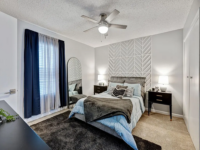Inviting bedroom with modern design featuring textured accent wall, cozy bedding, ambient lighting, and chic decor.