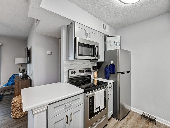 Contemporary kitchen with sleek stainless steel appliances, elegant cabinetry, and modern lighting, offering a stylish and functional space.