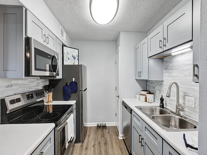 Modern kitchen with stainless steel appliances, elegant cabinetry, and pristine countertops creating a sleek and functional cooking space.