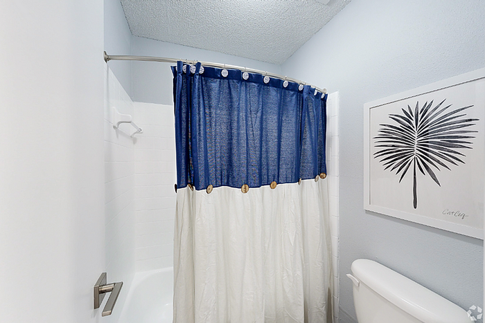 Charming bathroom with a stylish blue and white shower curtain, elegant wall art, and modern fixtures.