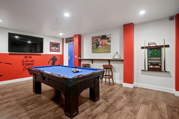 Vibrant game room with a stylish pool table, modern decor, and a cozy bar area, perfect for entertaining.