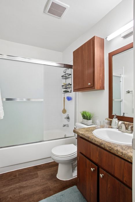 Modern bathroom with elegant wooden cabinets, spacious bathtub, and sleek fixtures, offering a serene and stylish design.