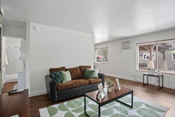 Bright and inviting living room with cozy seating, modern decor, and large windows offering abundant natural light.