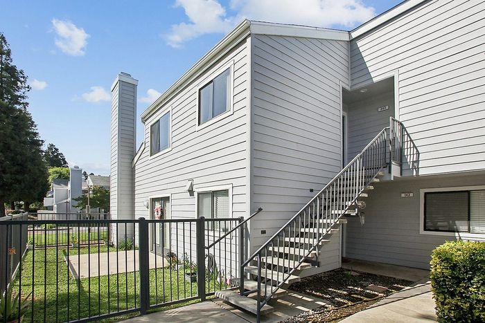 Charming two-story apartment building with a private gated entrance and modern exterior design.