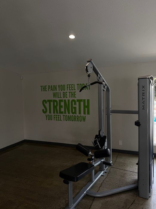 Modern fitness room with state-of-the-art exercise machine and motivational wall quote for inspiration.