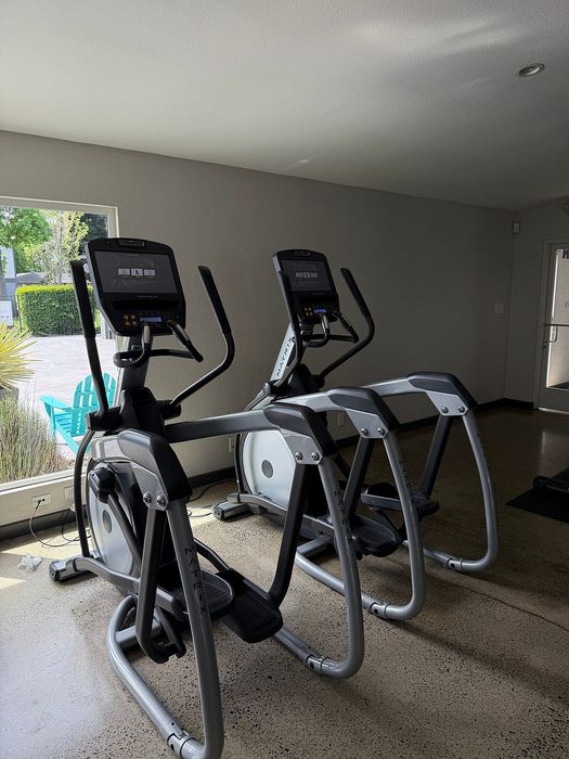Modern fitness room with sleek exercise bikes positioned near a bright window, offering a refreshing workout environment.