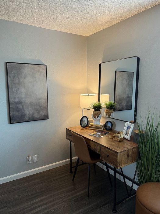 Chic home office nook featuring a rustic wooden desk, modern decor, and elegant lighting.