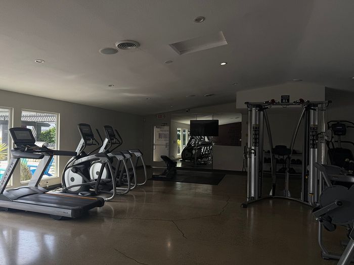 Modern fitness center with state-of-the-art exercise machines and bright natural lighting.