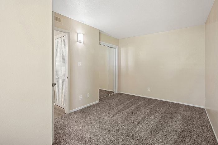 Bright and inviting room with soft carpet flooring and neutral walls, perfect for personalization and comfort.