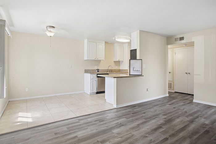 Bright and inviting open-concept space with modern flooring, sleek kitchen cabinetry, and ample natural light.