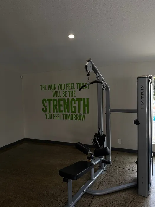 Contemporary gym corner with motivational quote, featuring a sleek exercise machine and inviting natural light.