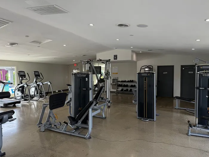 Modern fitness center equipped with state-of-the-art exercise machines and ample space for a dynamic workout.