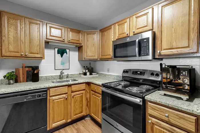 Modern kitchen with elegant wooden cabinets, granite countertops, and stainless steel appliances for a stylish cooking experience.